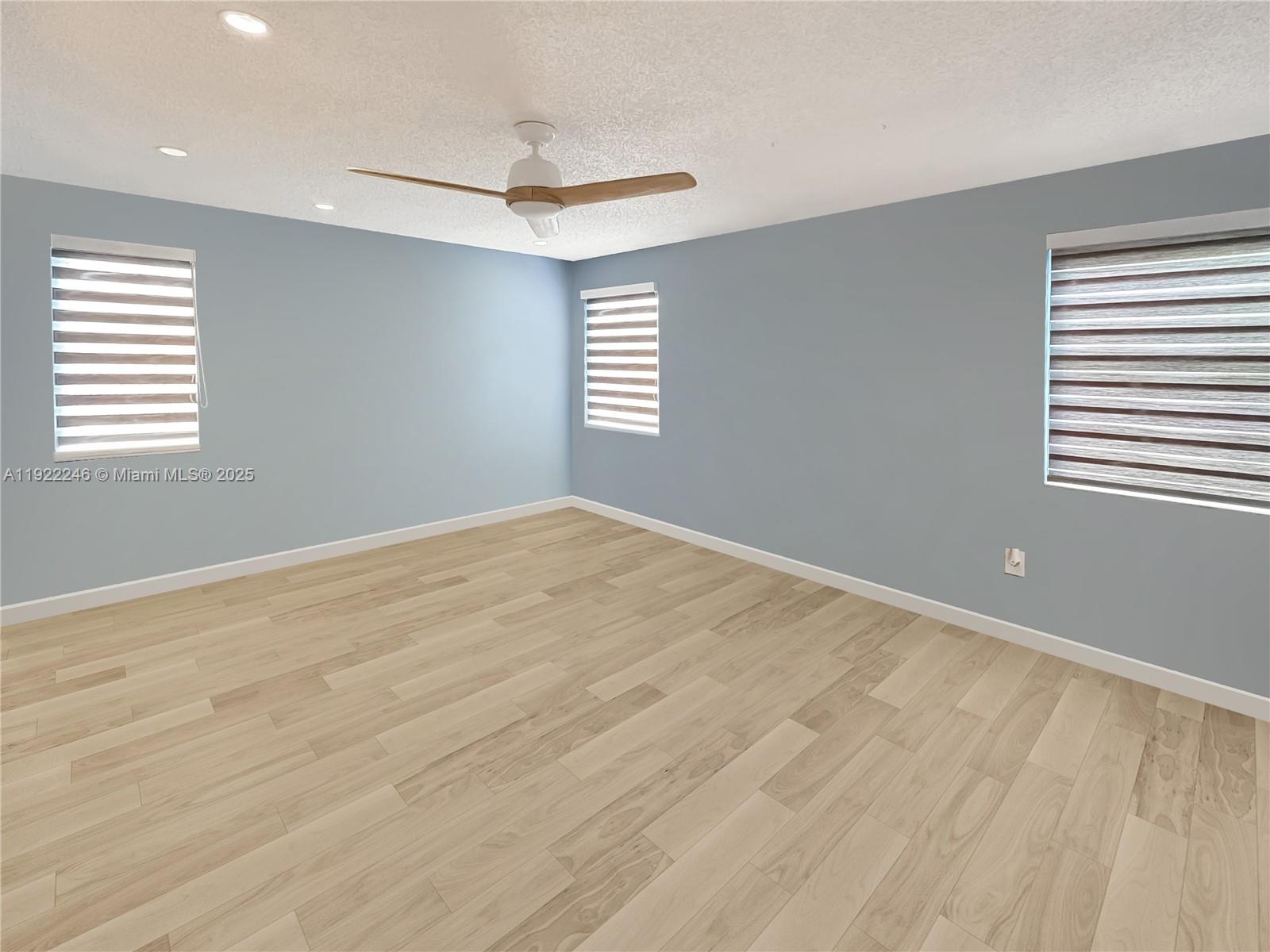 12759 Southwest 146th Terrace Miami, FL 33186 - Photo 4 of 10 an empty room with windows and fan