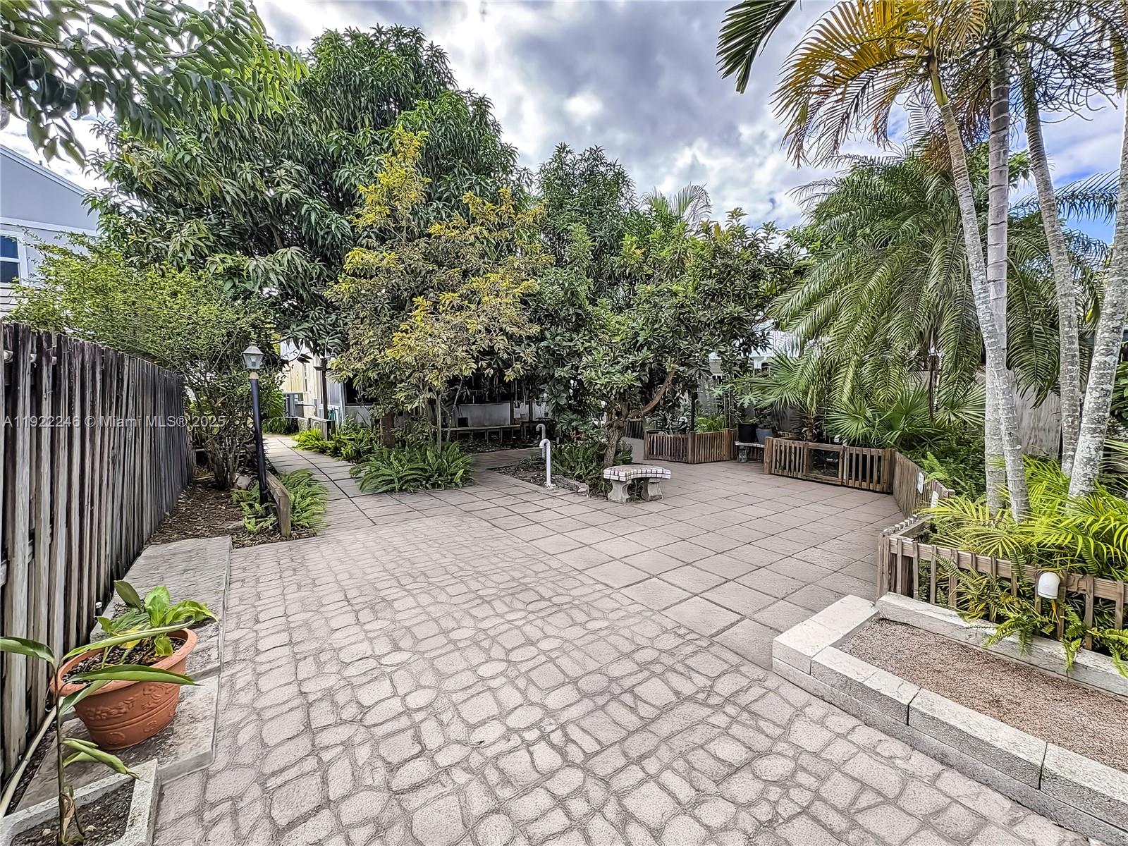 12759 Southwest 146th Terrace Miami, FL 33186 - Photo 7 of 10 a view of a backyard with chairs potted plants and large tree