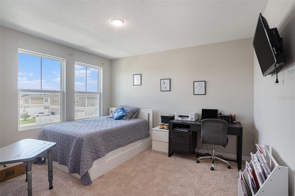 13005 Upward Place Riverview, FL 33579 - Photo 17 of 28 a bedroom with a bed and a flat screen tv
