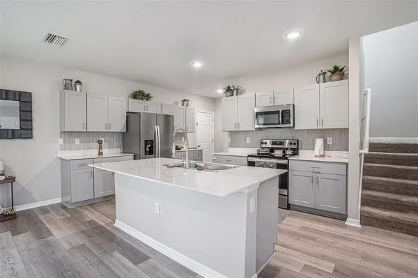 a kitchen with cabinets a sink and appliances