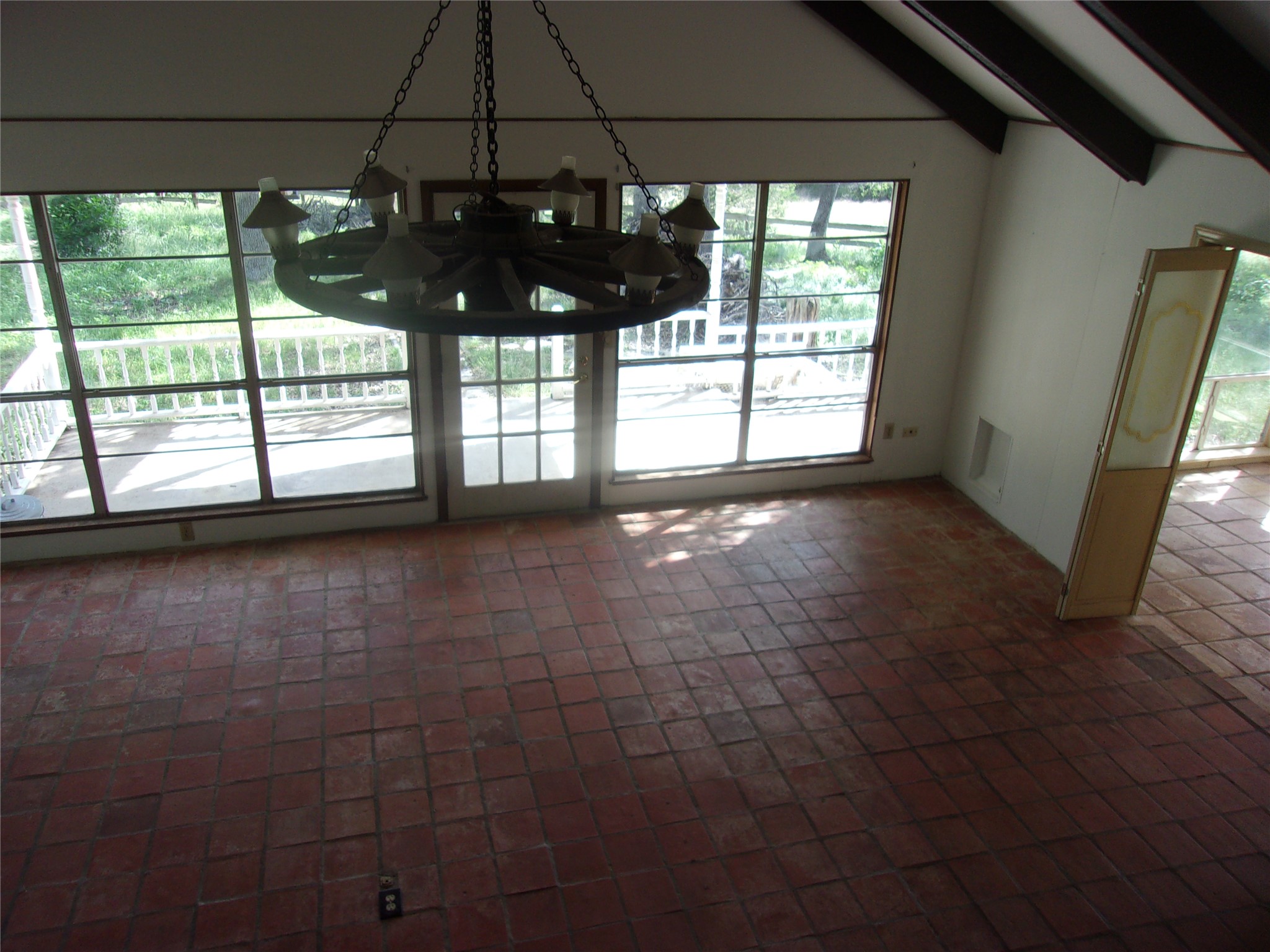 702 Cottonwood Creek Road Dripping Springs, TX 78620 - Photo 25 of 31 Spacious interior room featuring terra cotta tile flooring and a vaulted ceiling with exposed beams