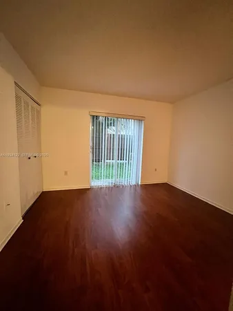 a view of a livingroom with wooden floor and a window