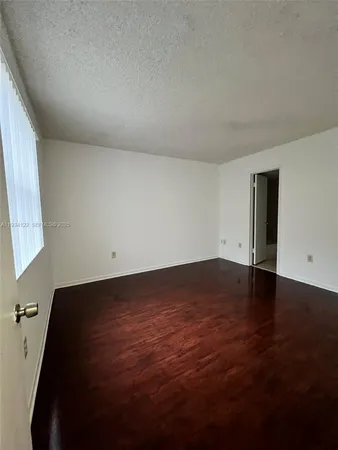 a view of room with window and wooden floor