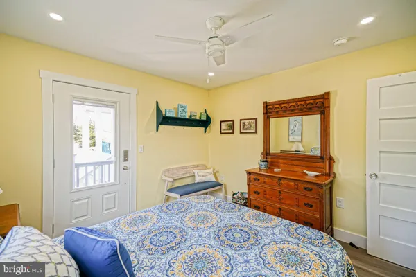 a bedroom with a bed and a lamp on table with wooden floor