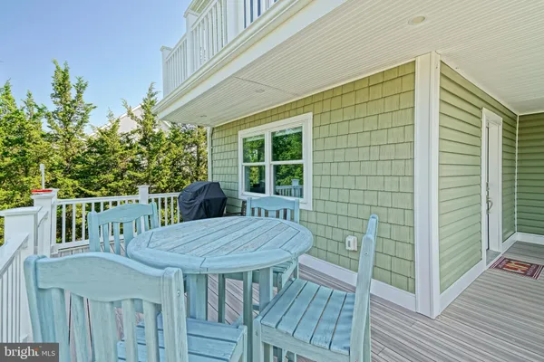 a view of a dining room with furniture a chandelier and wooden floor