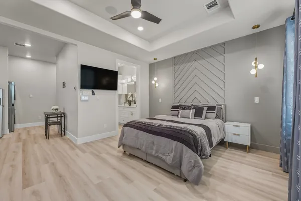 a spacious bedroom with a bed and a flat screen tv