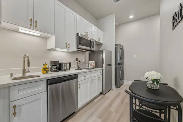a kitchen with stainless steel appliances kitchen island granite countertop a sink cabinets and wooden floor