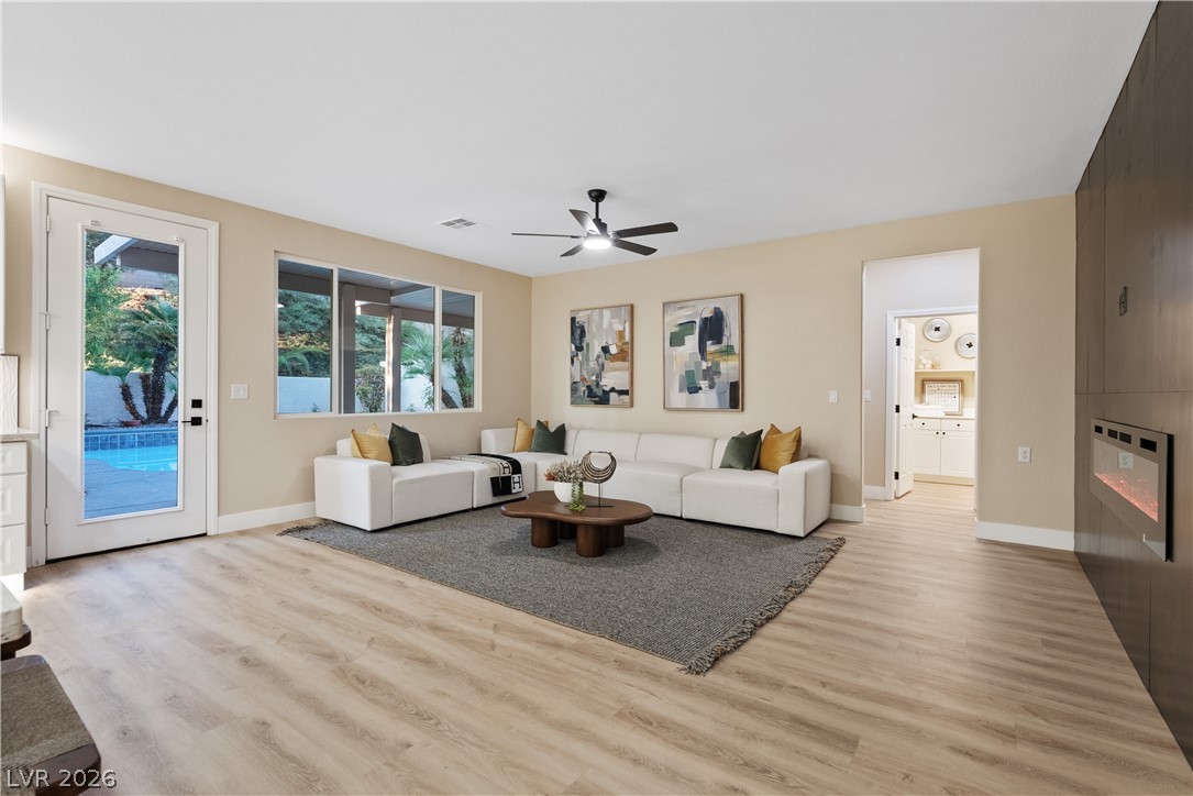 1662 Ravanusa Drive Henderson, NV 89052 - Photo 52 of 74 A chic living space featuring durable plank flooring and a sleek modern fireplace, opening to a private pool oasis.