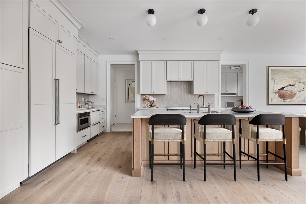 20 Common Court, Unit 20 Lexington, MA 02421 - Photo 7 of 27 a kitchen with stainless steel appliances a table chairs refrigerator and cabinets
