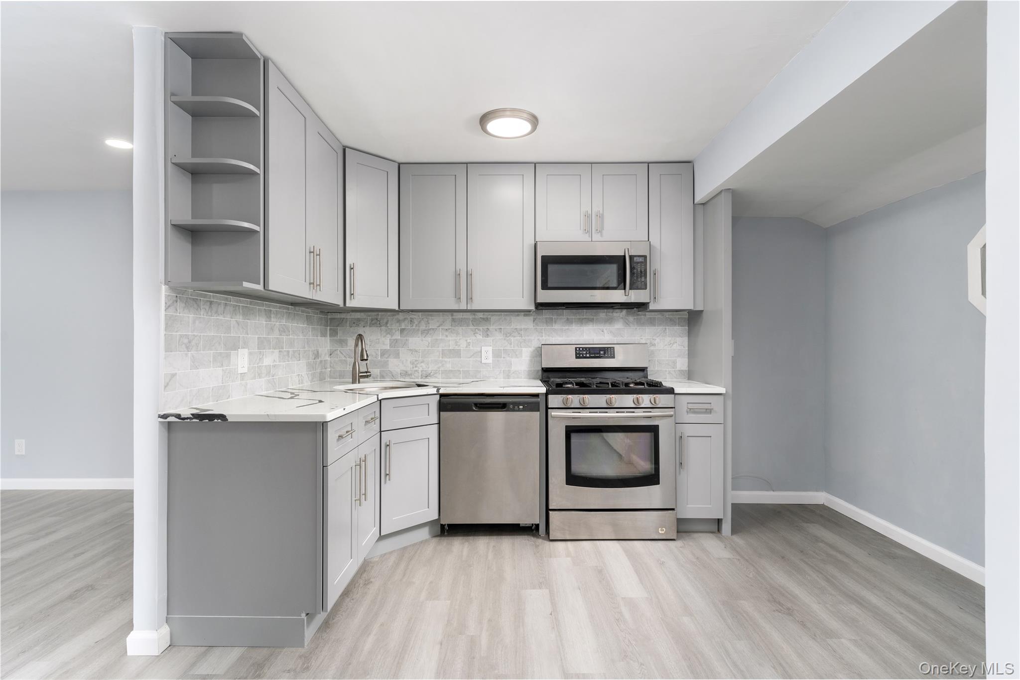 48 Hawkins Road Centereach, NY 11720 - Photo 2 of 22 a kitchen with stainless steel appliances granite countertop a stove a sink and a microwave