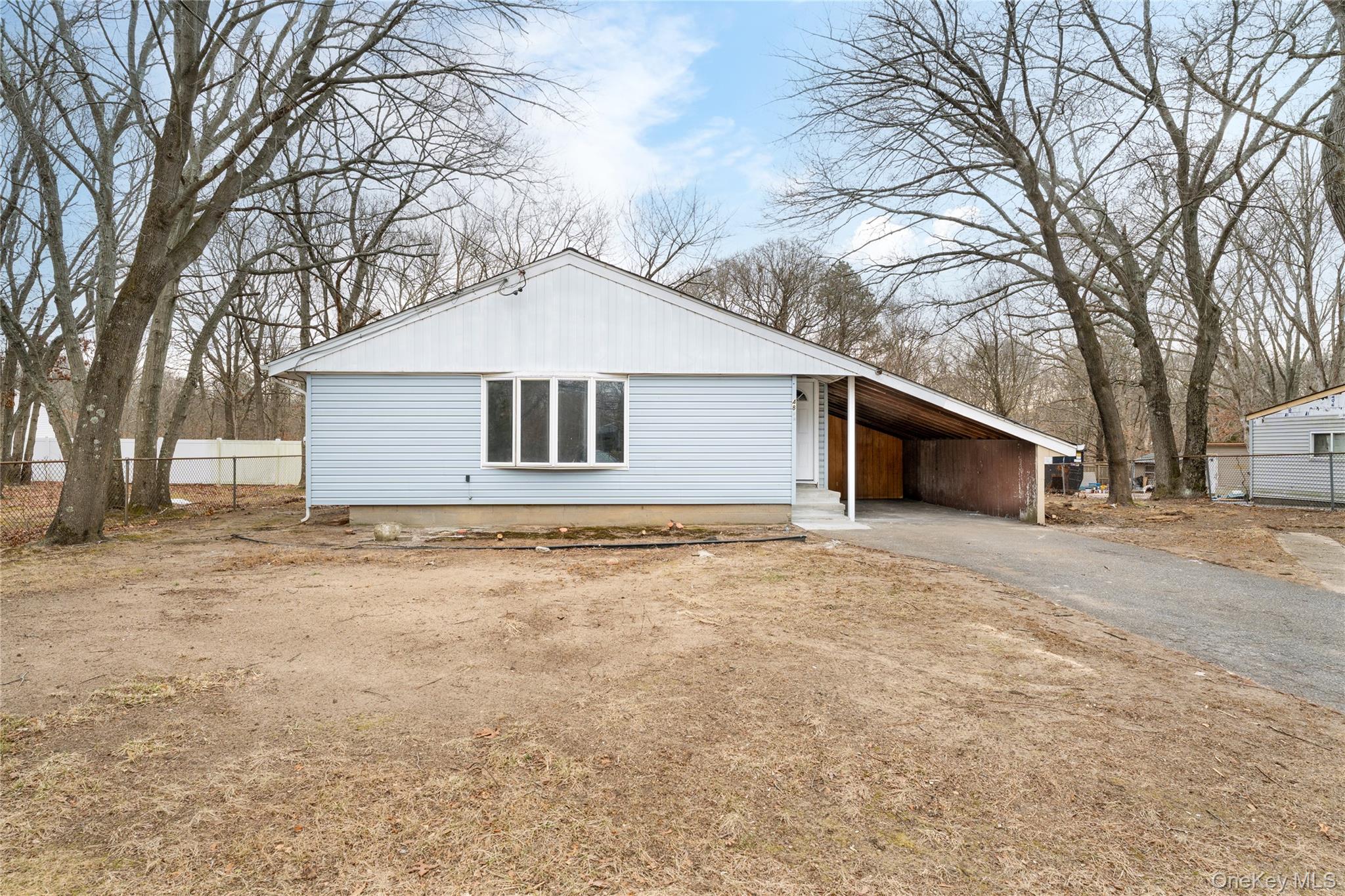 48 Hawkins Road Centereach, NY 11720 - Photo 3 of 22 a house with trees in front of it