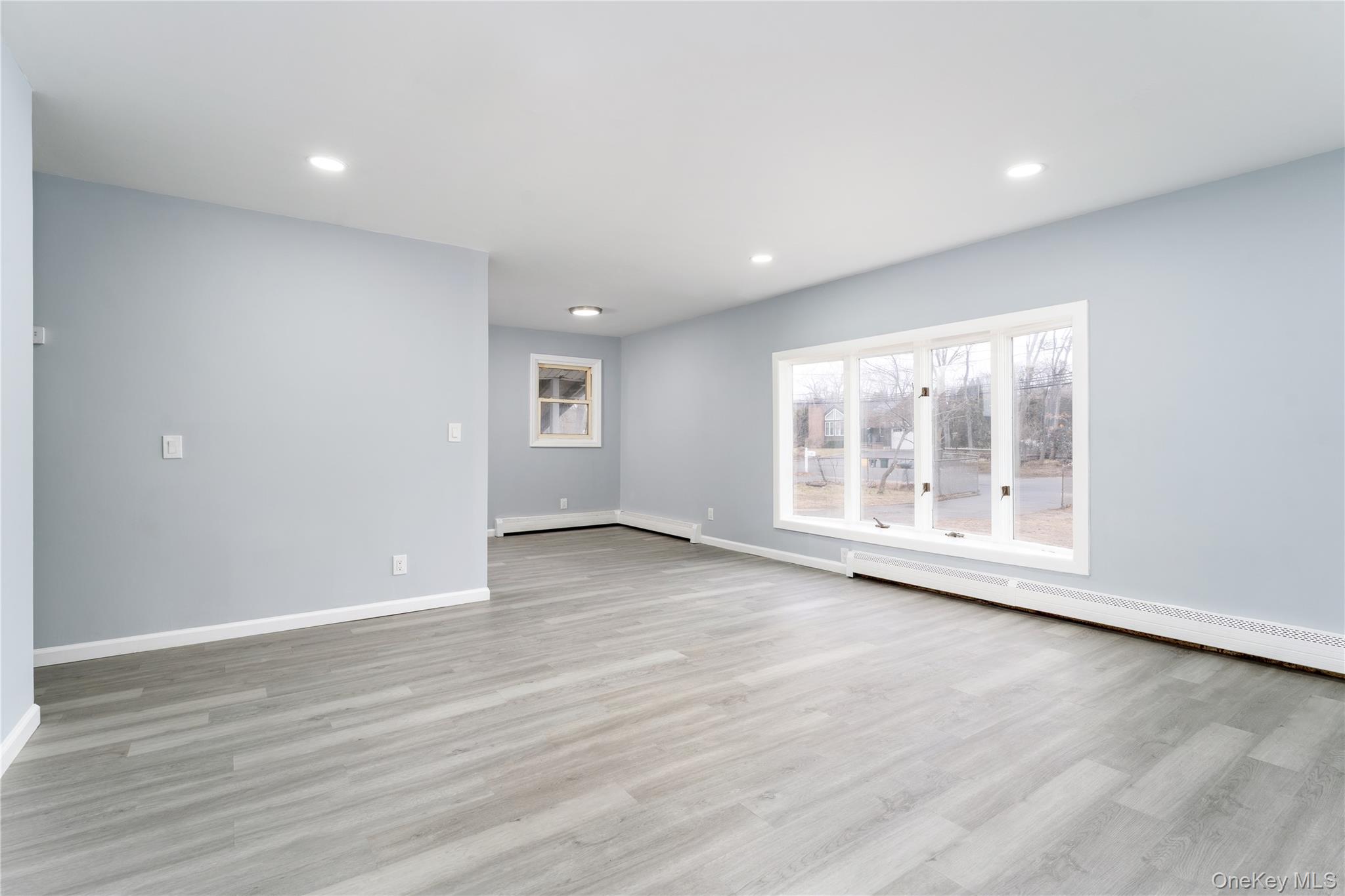 48 Hawkins Road Centereach, NY 11720 - Photo 4 of 22 an empty room with wooden floor and windows