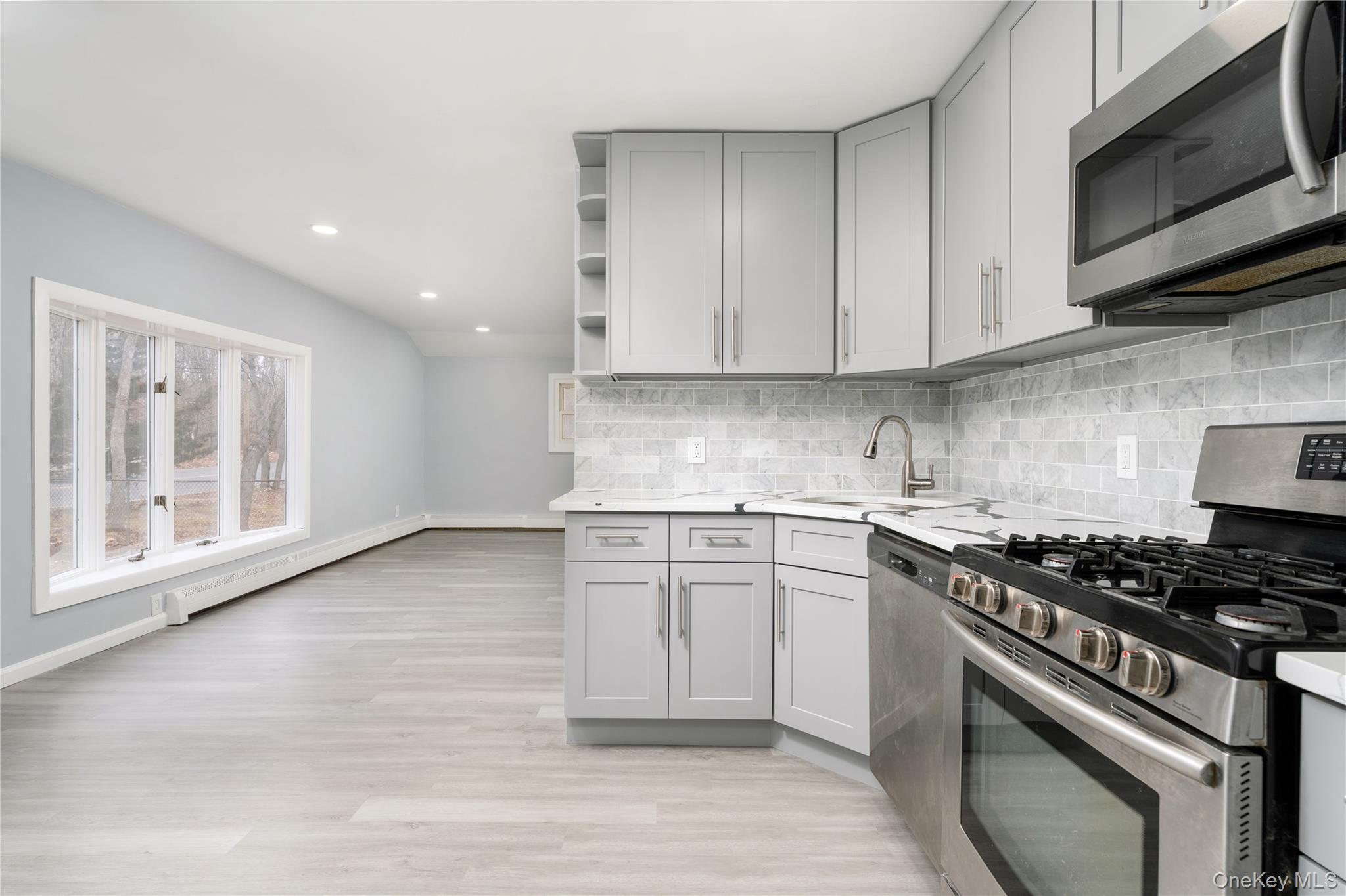 48 Hawkins Road Centereach, NY 11720 - Photo 6 of 22 a kitchen with stainless steel appliances granite countertop a stove a sink and a microwave