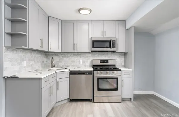 a kitchen with cabinets stainless steel appliances and wooden floor