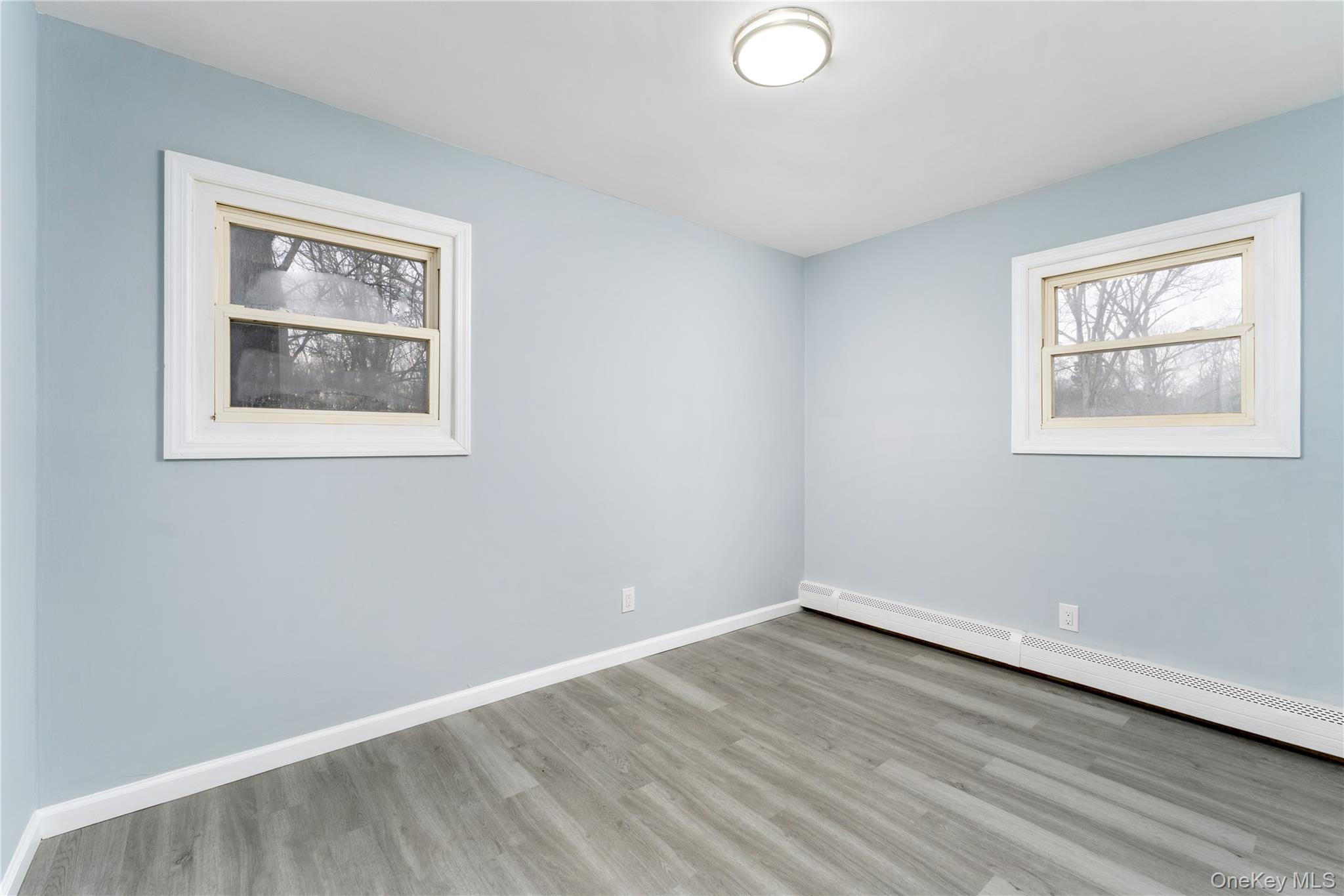 48 Hawkins Road Centereach, NY 11720 - Photo 10 of 22 a view of an empty room with wooden floor and a window