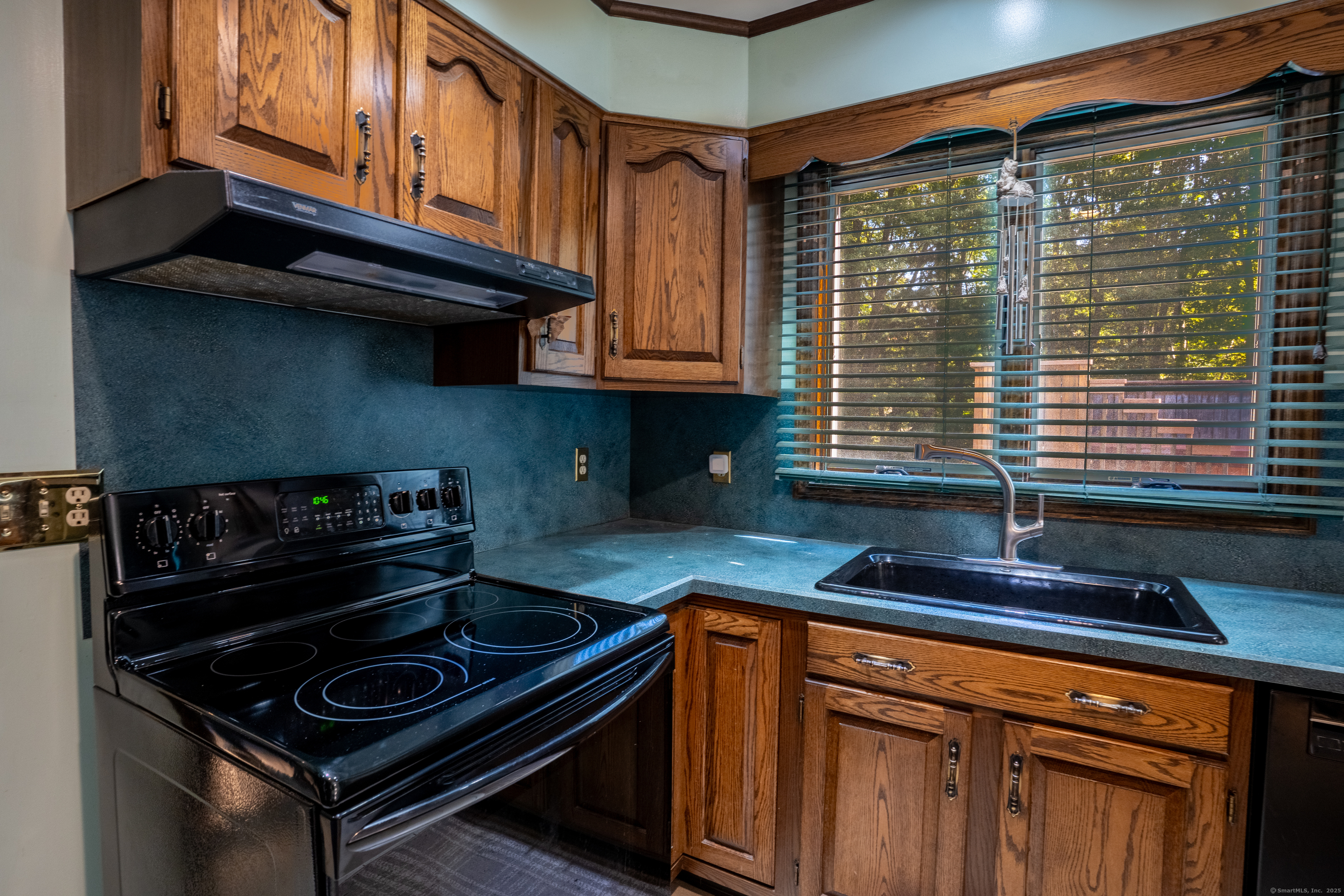 124 Bagburn Hill Road Monroe, CT 06468 - Photo 5 of 34 a kitchen with granite countertop cabinets and black stainless steel appliances