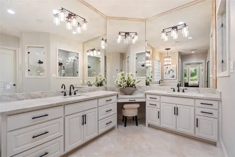 a spacious bathroom with a granite countertop sink a large mirror a bathtub and vanity