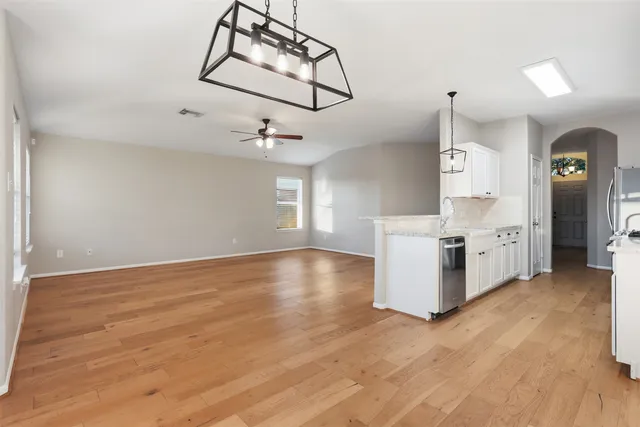 a view of a kitchen with wooden floor and windows