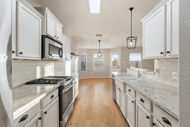 a kitchen with stainless steel appliances granite countertop a stove a sink and a granite counter tops