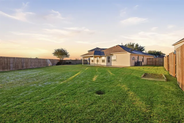 a aerial view of a house next to a big yard and large trees