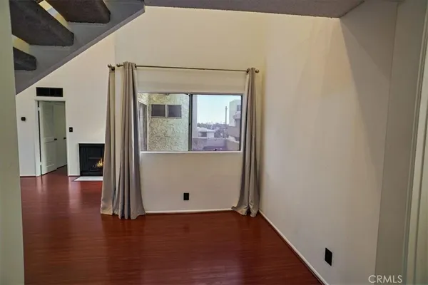 a view of a hallway with wooden floor and a cabinet