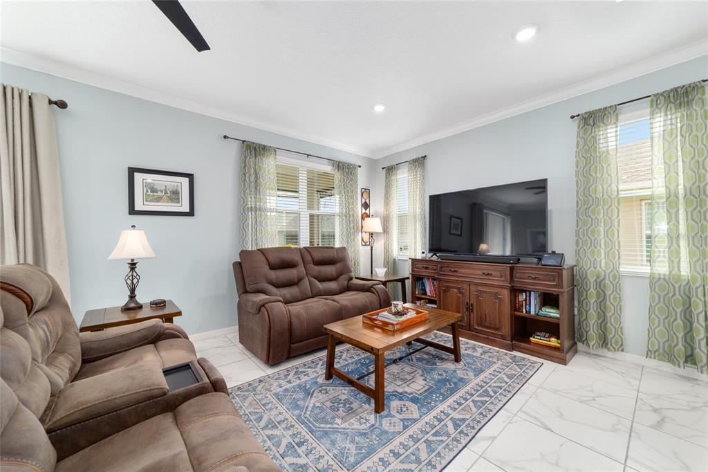 7765 Southwest 80th Pl Road Ocala, FL 34476 - Photo 12 of 37 a living room with furniture and a flat screen tv
