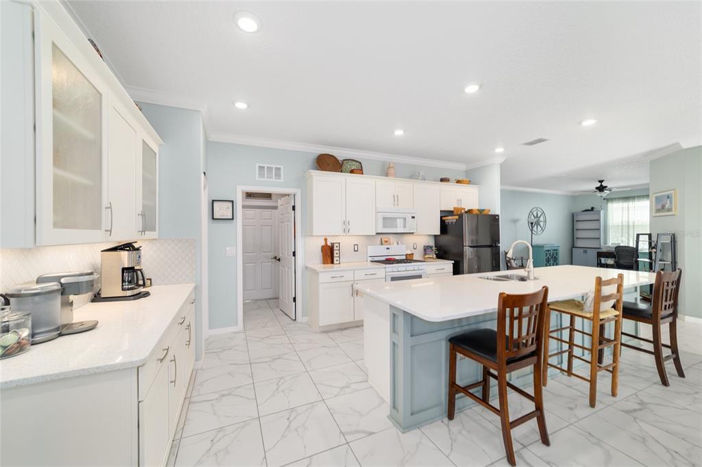 7765 Southwest 80th Pl Road Ocala, FL 34476 - Photo 18 of 37 a kitchen with white cabinets and stainless steel appliances