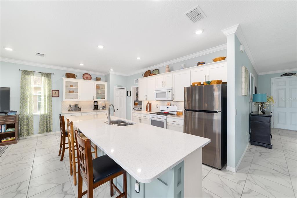 7765 Southwest 80th Pl Road Ocala, FL 34476 - Photo 19 of 37 a kitchen with refrigerator and chairs