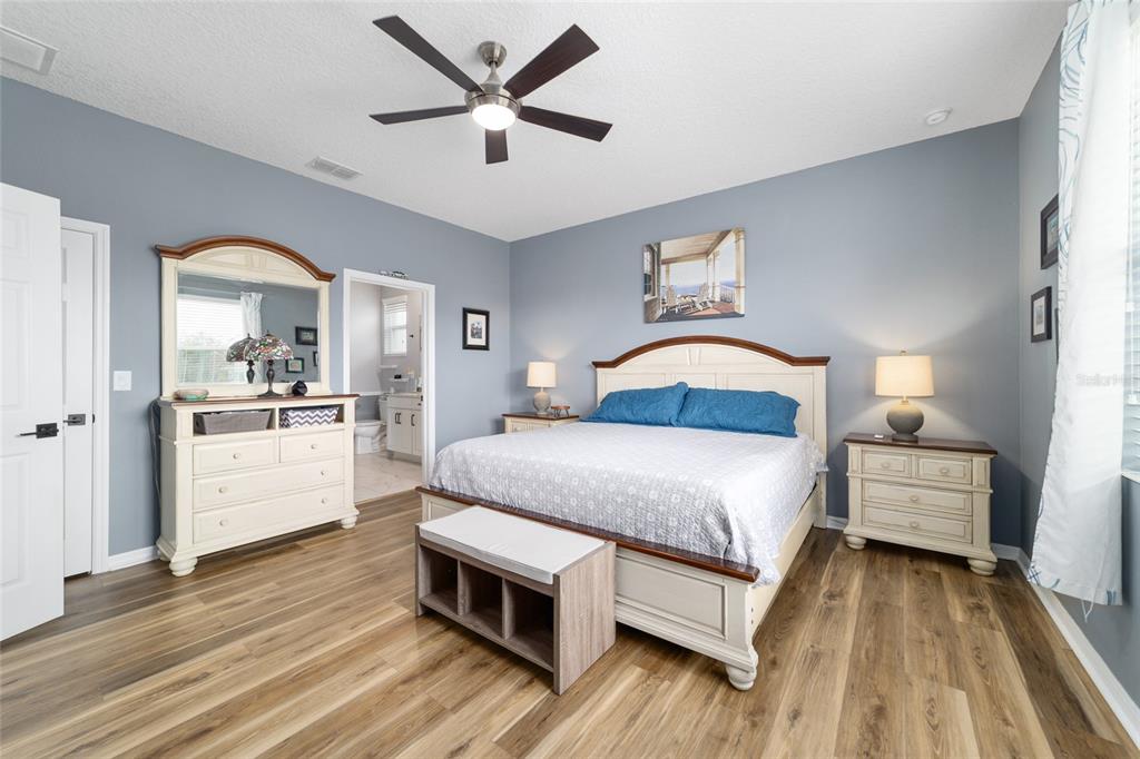 7765 Southwest 80th Pl Road Ocala, FL 34476 - Photo 24 of 37 a bedroom with a bed and a chandelier