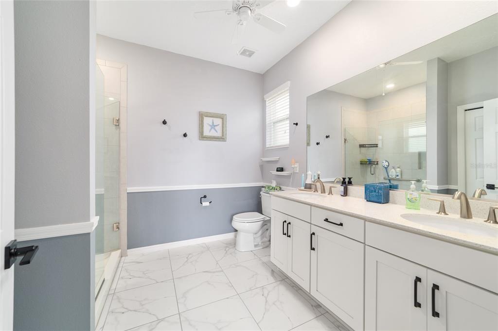7765 Southwest 80th Pl Road Ocala, FL 34476 - Photo 26 of 37 a spacious bathroom with a double vanity sink mirror and toilet