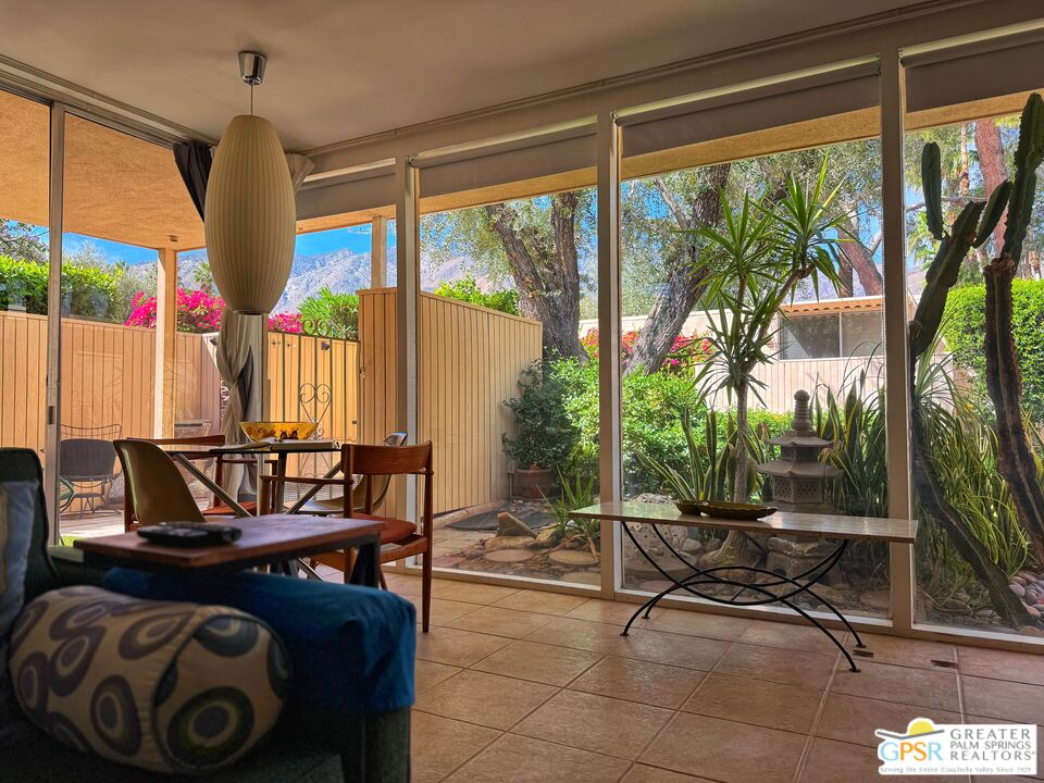 360 Cabrillo Road, Unit 220 Palm Springs, CA 92262 - Photo 14 of 57 a living room with patio furniture and a floor to ceiling window