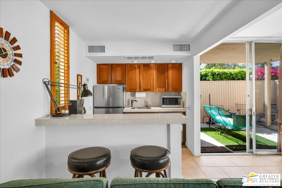 360 Cabrillo Road, Unit 220 Palm Springs, CA 92262 - Photo 19 of 57 a kitchen with a stove a table and chairs in it
