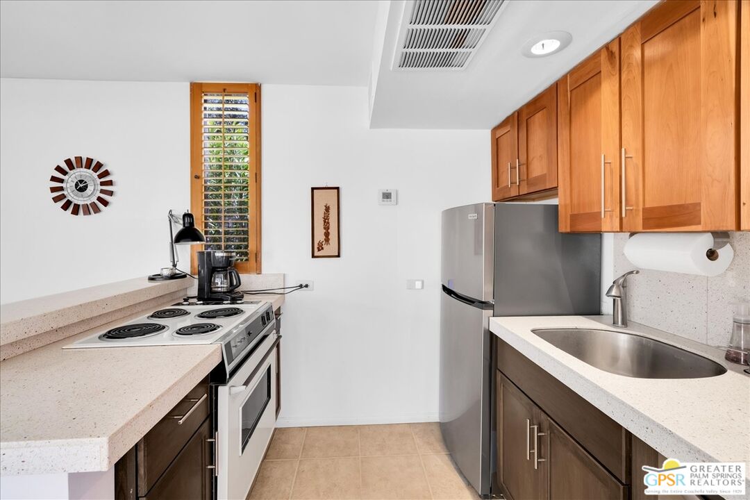 360 Cabrillo Road, Unit 220 Palm Springs, CA 92262 - Photo 21 of 57 a kitchen with stainless steel appliances granite countertop a sink stove and refrigerator