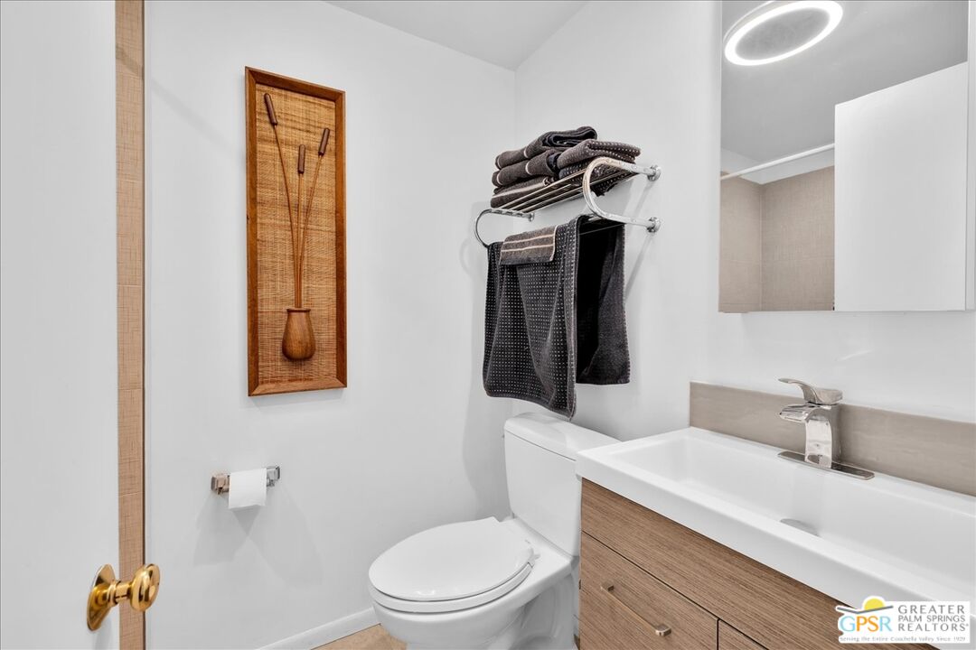 360 Cabrillo Road, Unit 220 Palm Springs, CA 92262 - Photo 28 of 57 a bathroom with a toilet a sink and mirror