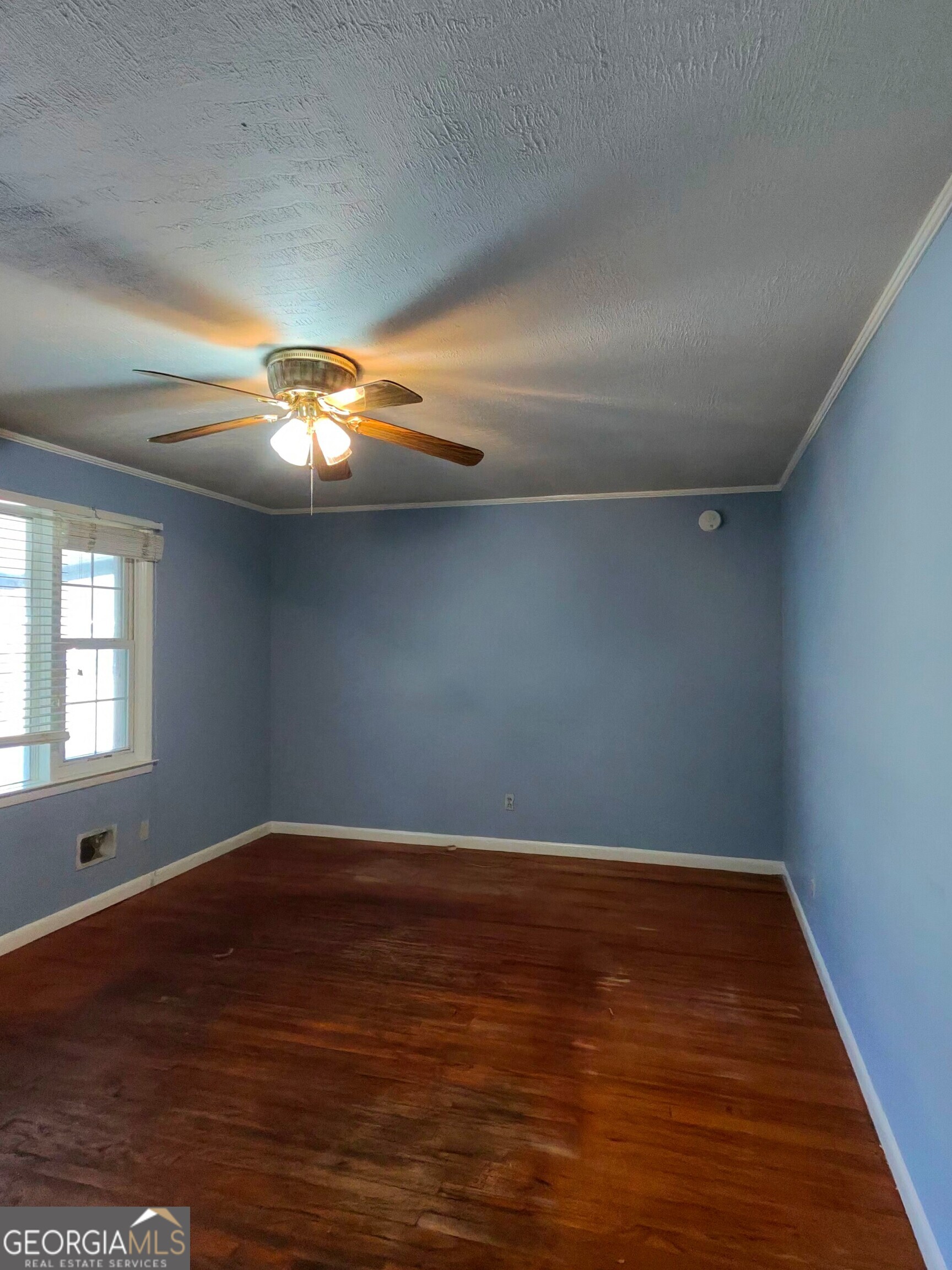 110 Lee Street Centerville, GA 31028 - Photo 4 of 18 an empty room with wooden floor chandelier fan and windows