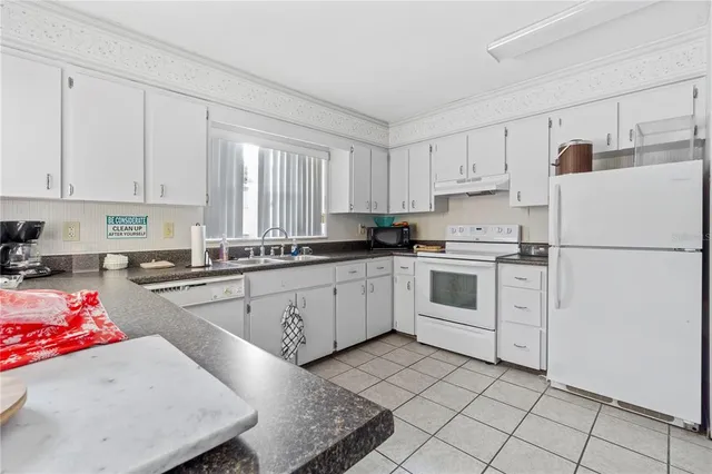 a kitchen with white cabinets and white appliances