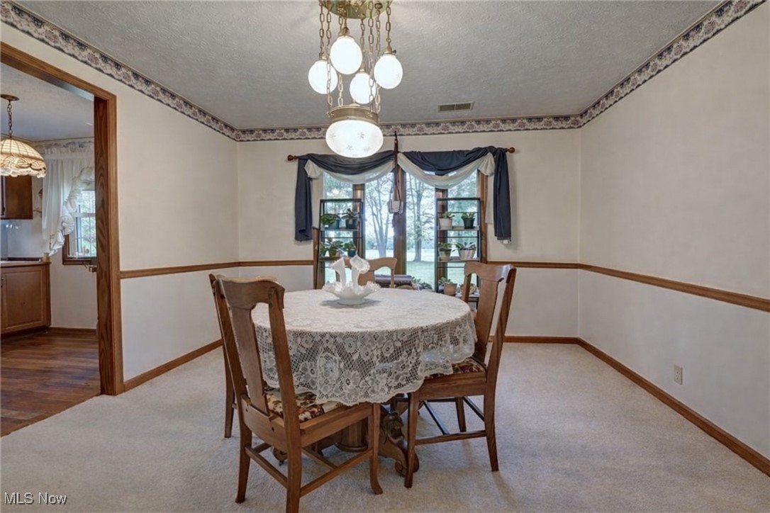 14965 Seacrist Road Salem, OH 44460 - Photo 10 of 43 Carpeted dining area featuring a textured ceiling and a chandelier