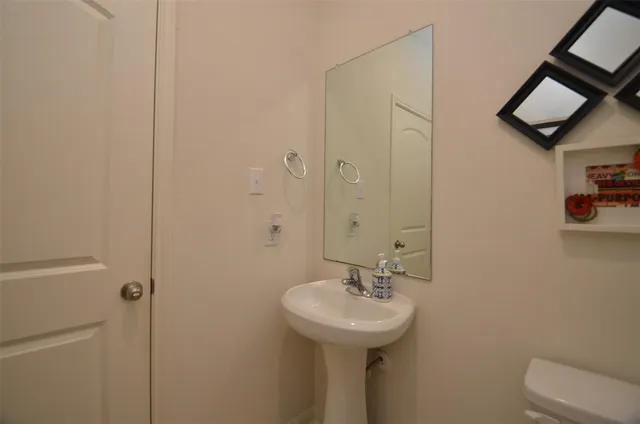 a bathroom with a sink toilet and mirror
