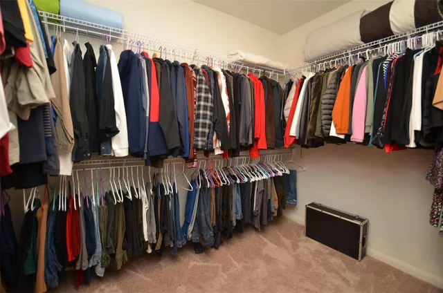 a view of walk in closet with clothes