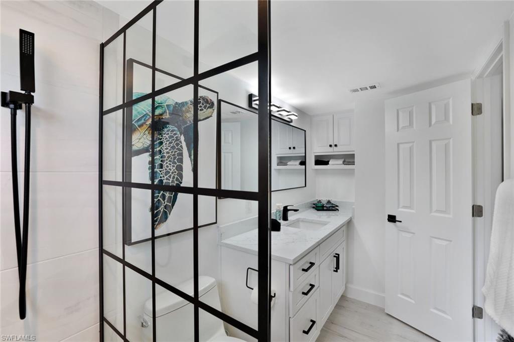 960 7th Street South, Unit 105 Naples, FL 34102 - Photo 11 of 19 Beautifully renovated bathroom featuring a modern glass shower enclosure and clean lines.