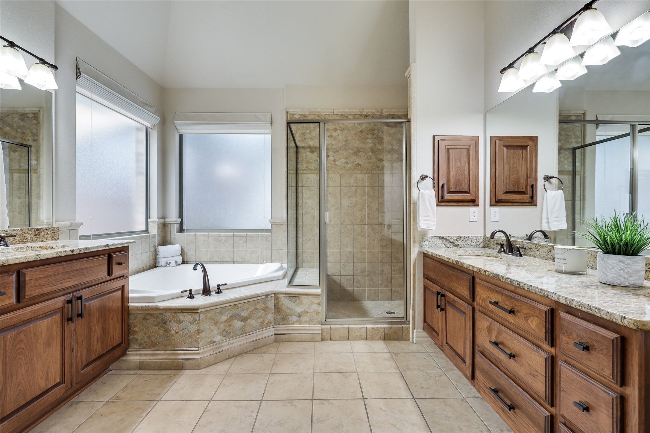 408 Ridgetop Bend Cedar Park, TX 78613 - Photo 24 of 40 Dual vanities with granite counters complement the deep soaking tub and glass-enclosed shower.