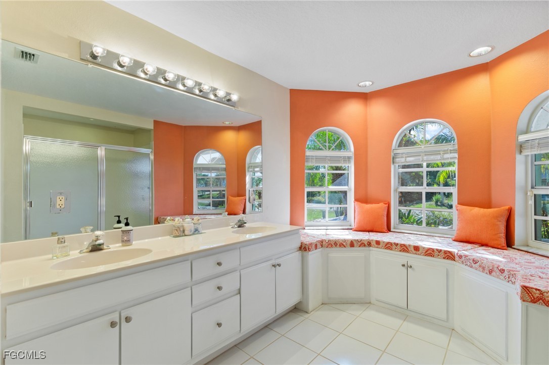 7660 Grande Pine Road Bokeelia, FL 33922 - Photo 14 of 33 a spacious bathroom with double vanity windows a sink and a large mirror