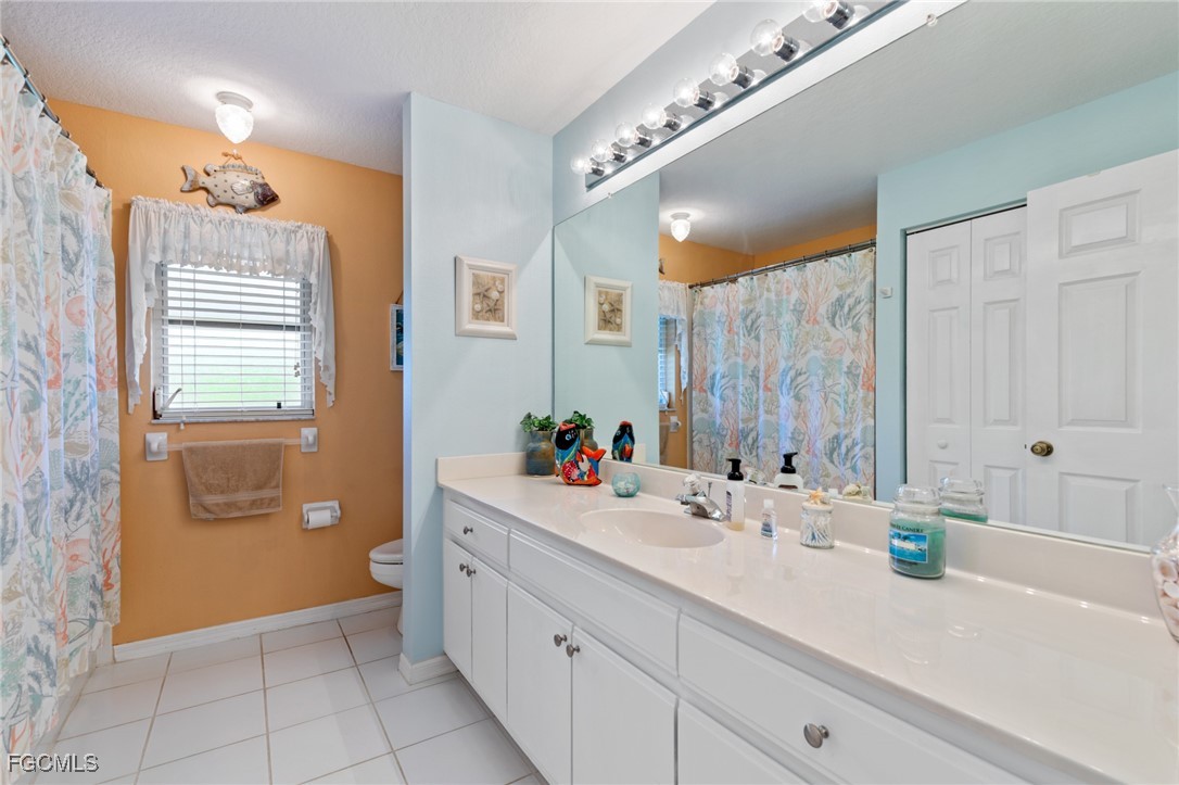 7660 Grande Pine Road Bokeelia, FL 33922 - Photo 17 of 33 a bathroom with a double vanity sink mirror and toilet