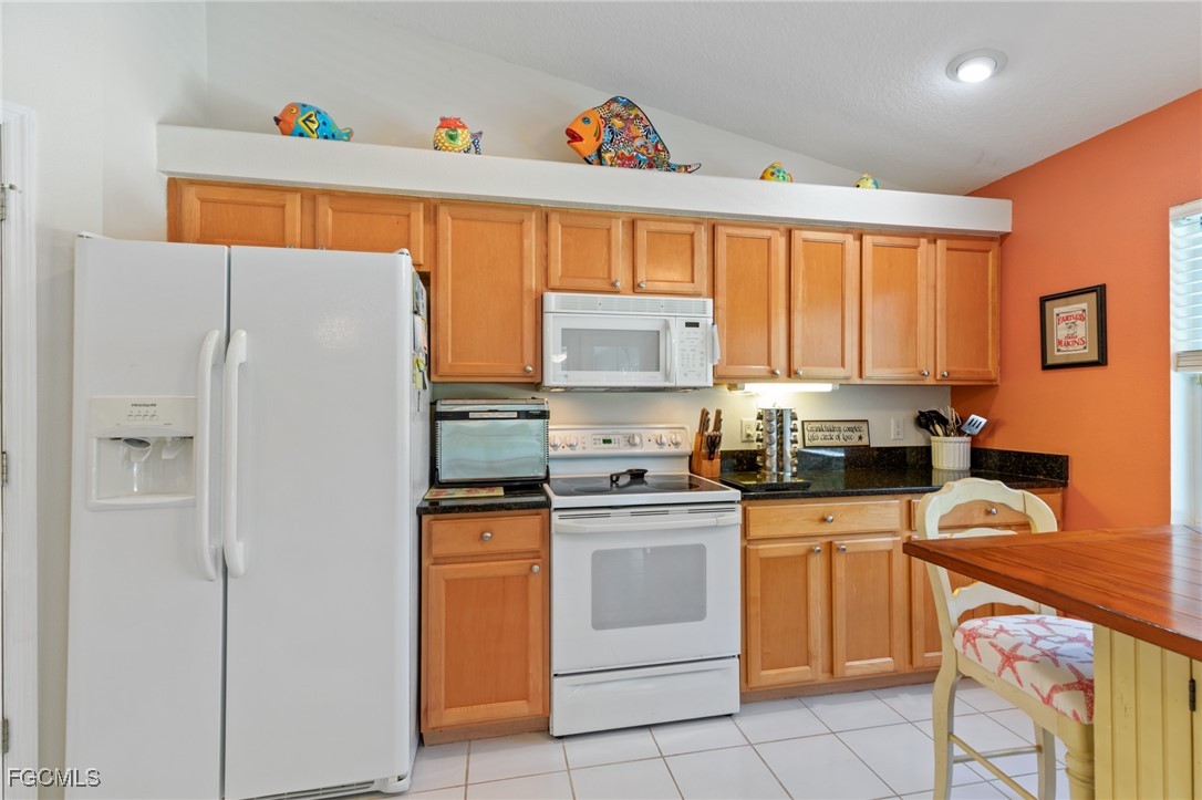 7660 Grande Pine Road Bokeelia, FL 33922 - Photo 9 of 33 a kitchen with a white cabinets and white appliances