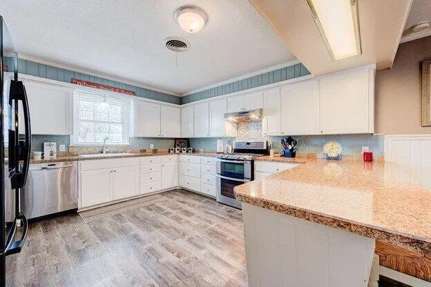 a kitchen with granite countertop white cabinets and white appliances