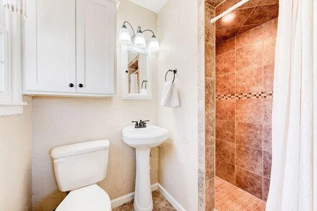 a white toilet sitting next to a bathroom sink