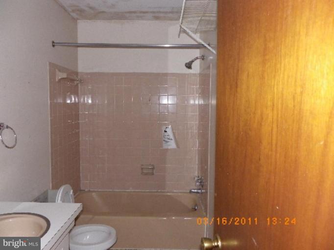 3510 Castleleigh Road Beltsville, MD 20705 - Photo 6 of 7 a bathroom with a granite countertop bathtub shower and a sink