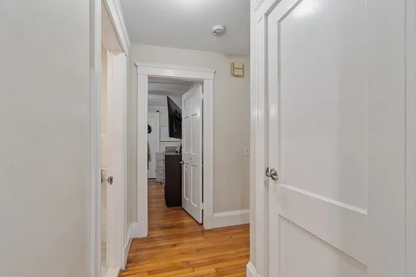 a view of a hallway with wooden floor and closet