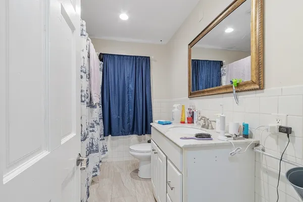 a bathroom with a sink toilet vanity and tub