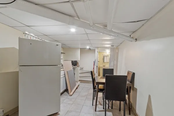 a view of a dining room with furniture and a refrigerator